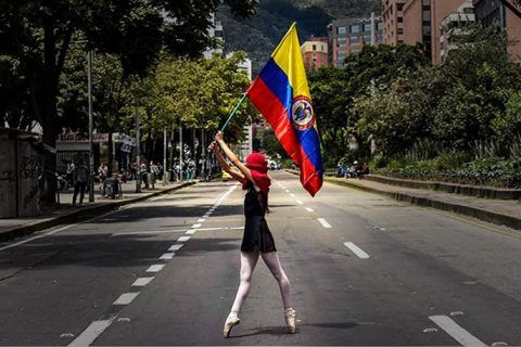 Mujer con bandera colombiana. Revueltas en Colombia. Crónica y pensamiento crítico en Cultugrafía.
