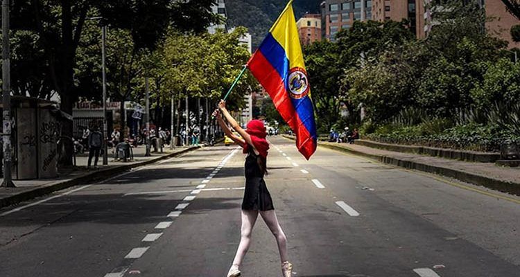 Mujer con bandera colombiana. Revueltas en Colombia. Crónica y pensamiento crítico en Cultugrafía.