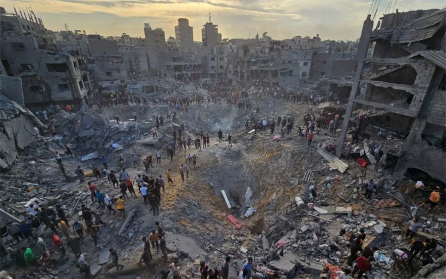 Premio Pulitzer de fotografía de noticias de última hora. 31 de octubre de 2023.ANAS AL-SHAREEF / REUTERS. Descripción: Los palestinos buscan víctimas en medio de profundos cráteres llenos de hormigón roto y metal retorcido, después de los ataques aéreos israelíes contra el campo de refugiados de Jabalia en el norte de la Franja de Gaza, el 31 de octubre de 2023.ANAS AL-SHAREEF / REUTERS