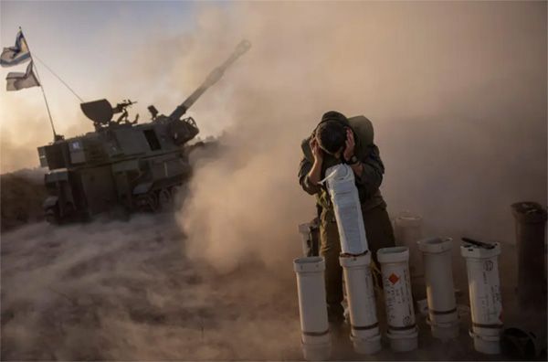 "Ganador del Premio Pulitzer de fotografía de noticias de última hora. Un soldado se cubre mientras una unidad de artillería móvil dispara proyectiles de 155 mm contra Gaza desde Netivot. 6 de noviembre de 2023 AMIR COHEN / REUTERS".