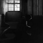 La imagen, de estilo expresionista, muestra a una mujer arrodillada, como si estuviera confesándose. Los comulgantes (1963), de Ingmar Bergman.