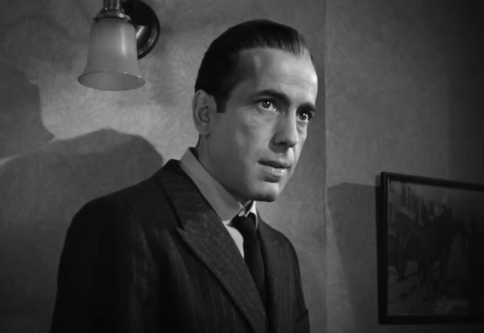 Humphrey Bogart encarna a Sam Spade en El halcón maltés (1941), arquetipo del detective cínico y desencantado. Su silueta, usualmente con gabardina, sombrero y cigarrillo, cristaliza la estética urbana y moralmente ambigua de la novela negra.