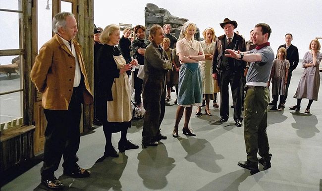 Lars Von Trier impartiendo instrucciones al excepcional elenco actoral de Dogville, en el que, aparte de Nicole Kidman, figuran dos grandes del Hollywood clásico, Lauren Bacall y James Caan. Un escenario “teatral” “transformado”, genialidad mediante, en puro cine.
